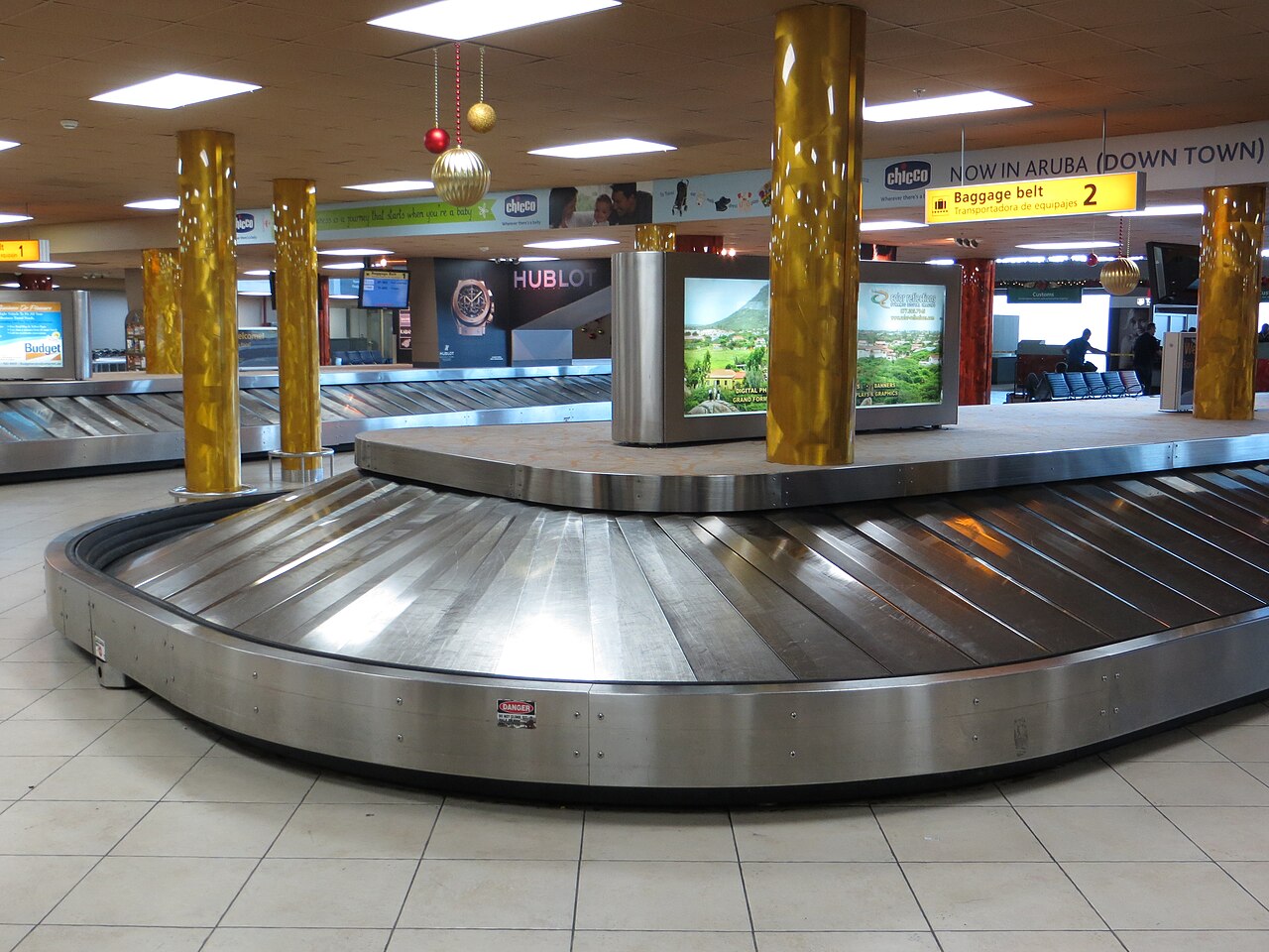 A baggage claim carousel, the rotating metal belt where arriving passengers collect their checked bags