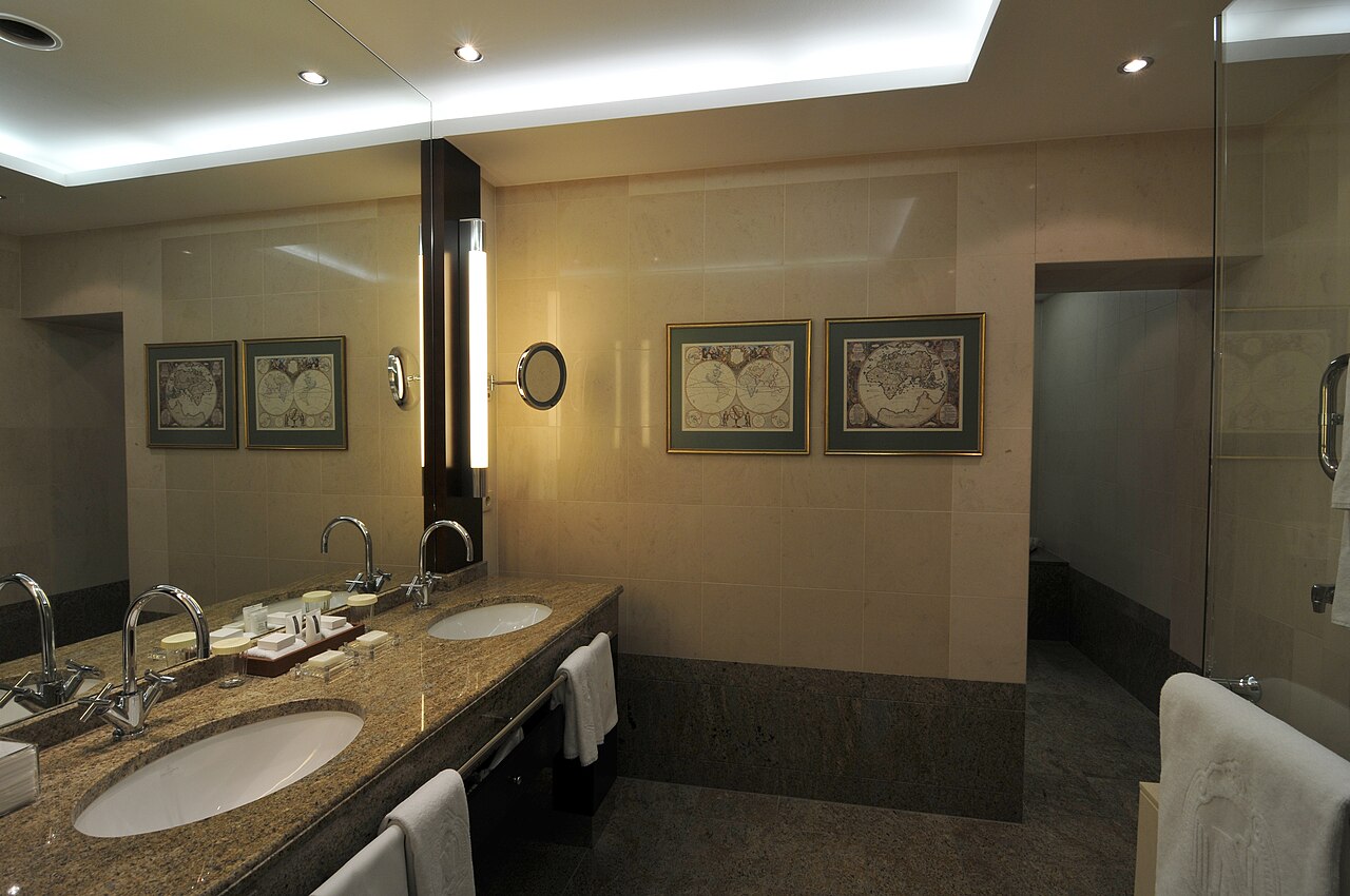 A bathroom sink with a faucet and a large mirror above it