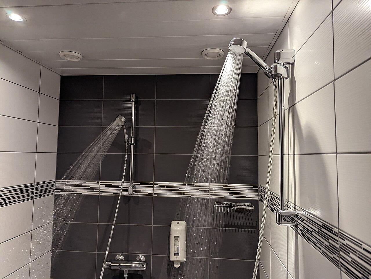 Water running from a showerhead in a tiled shower