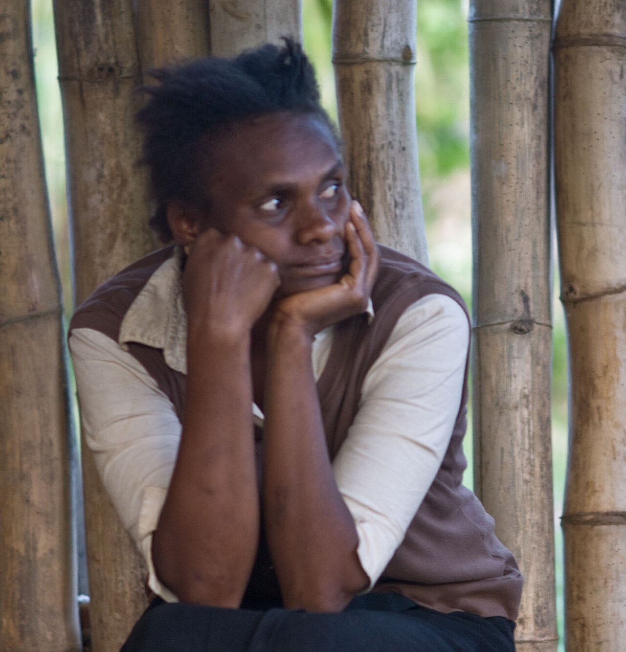 A young person resting their chin on their hands