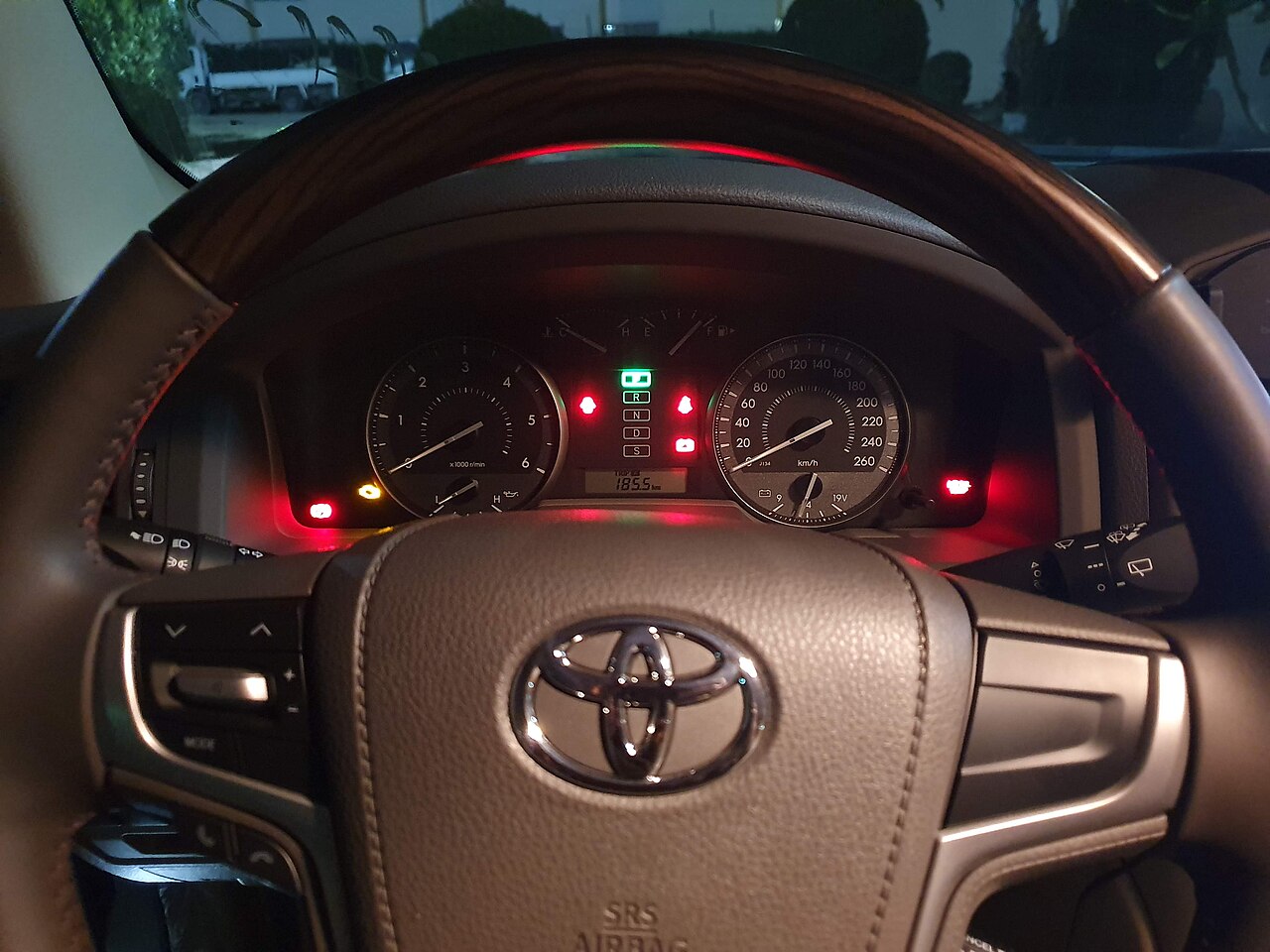 A car steering wheel and the dashboard instruments behind it (the speedometer and tachometer)