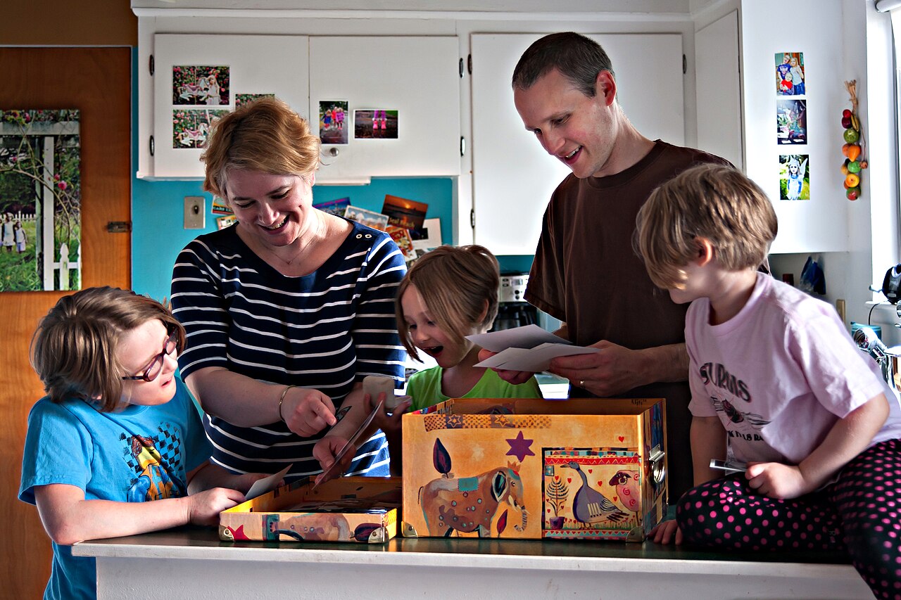 A family gathered in the kitchen at home, smiling together