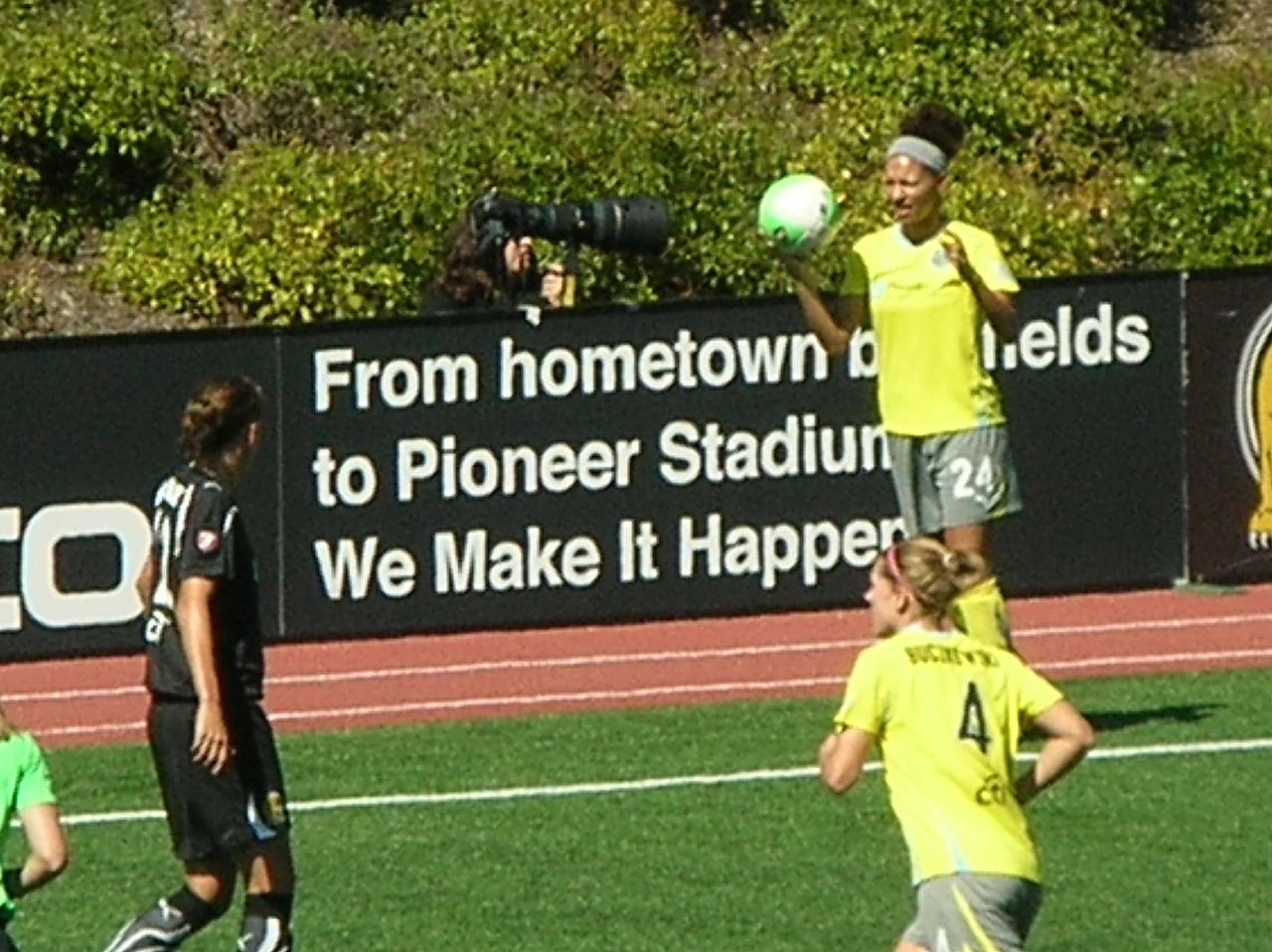 A player holding the ball above her head to take a throw-in
