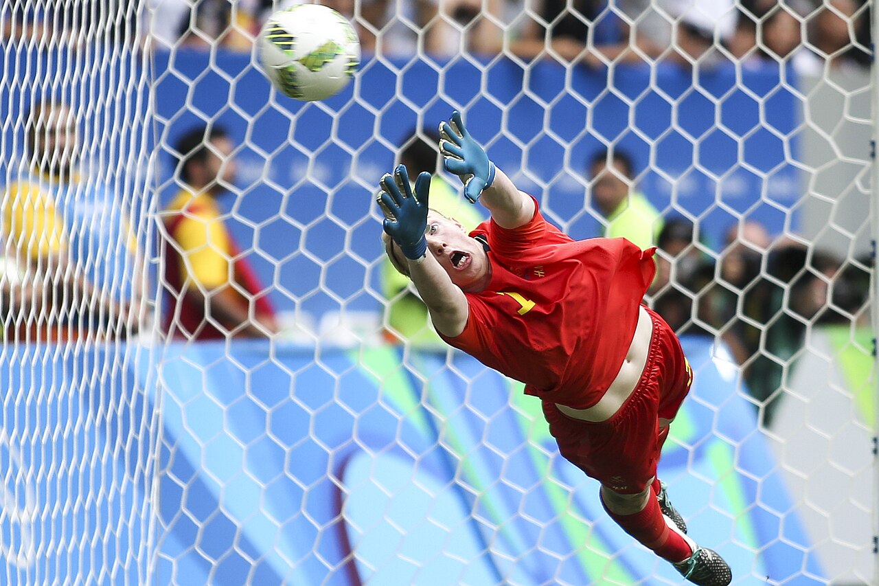 A goalkeeper diving across the goal to make a save