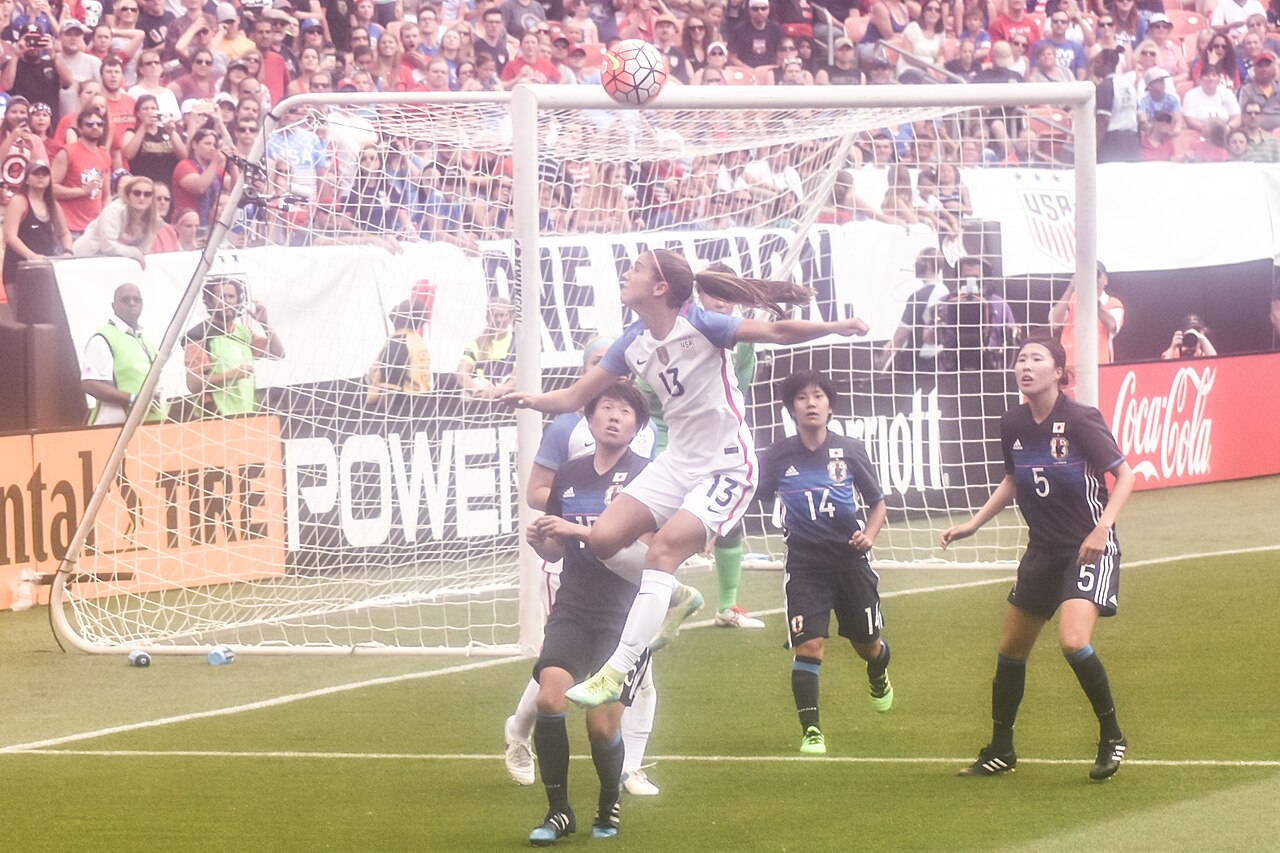 A player jumping above defenders to head the ball near the goal