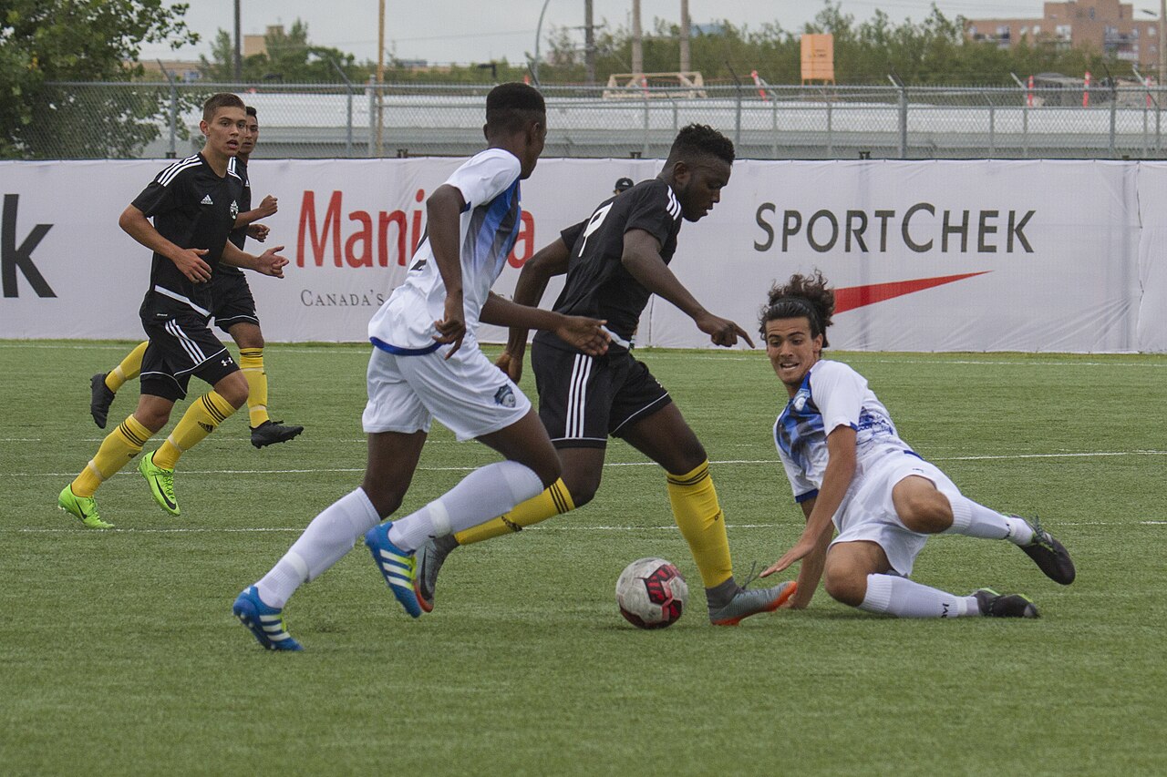 A defender sliding in to tackle an opponent and win the ball