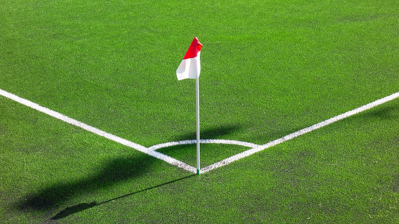 A corner flag standing at the corner of a soccer field