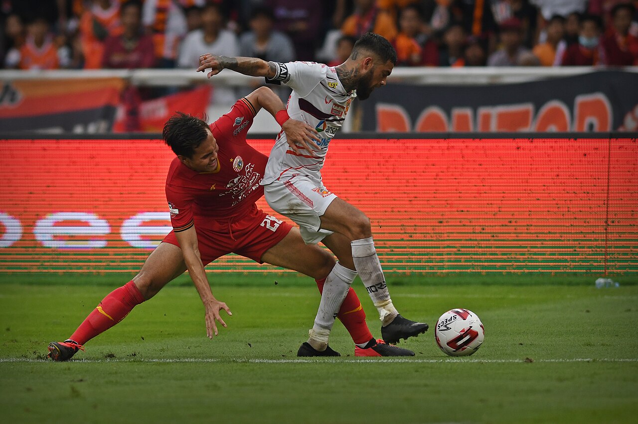 Two outfield players competing for the ball during a match
