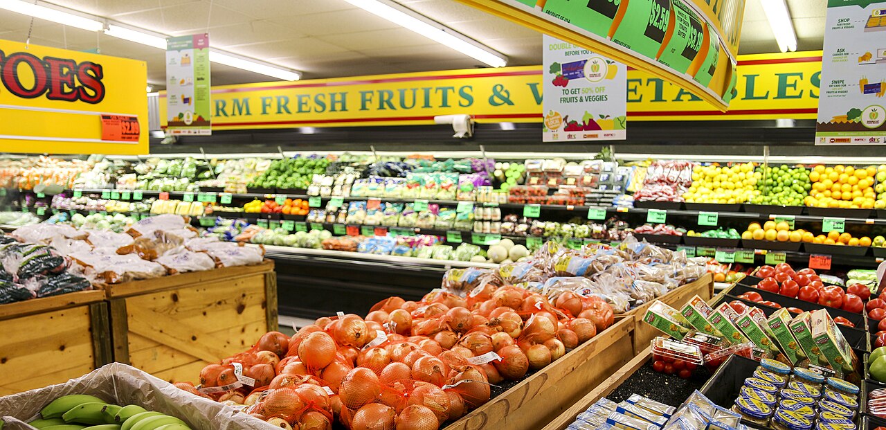 The produce section of an American grocery store, with crates and shelves of fresh fruits and vegetables