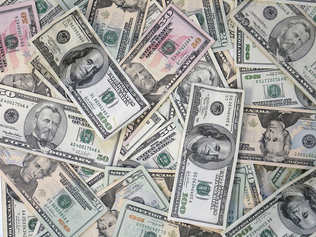A large pile of US dollar bills in different denominations