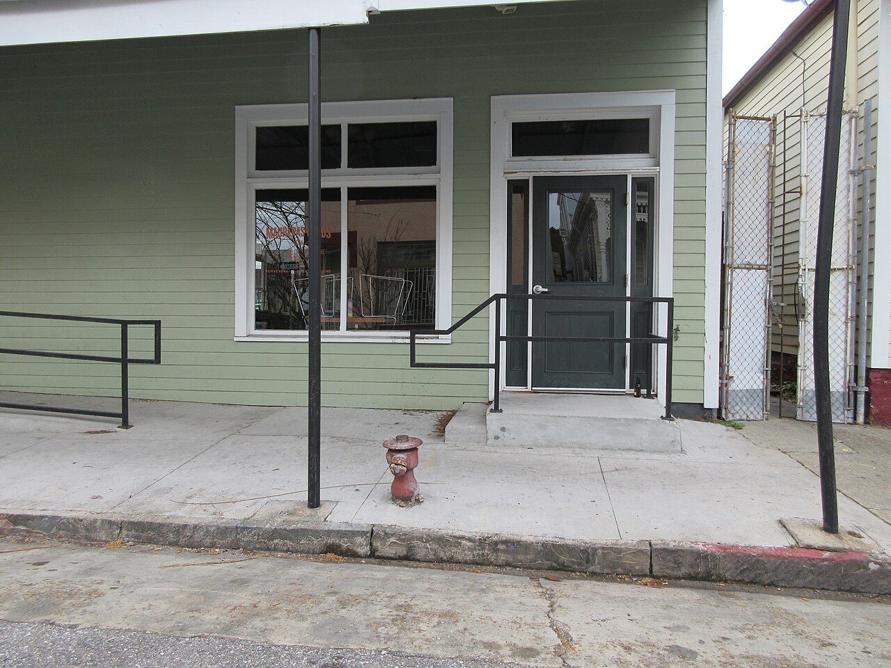 A red fire hydrant on a concrete sidewalk beside the curb
