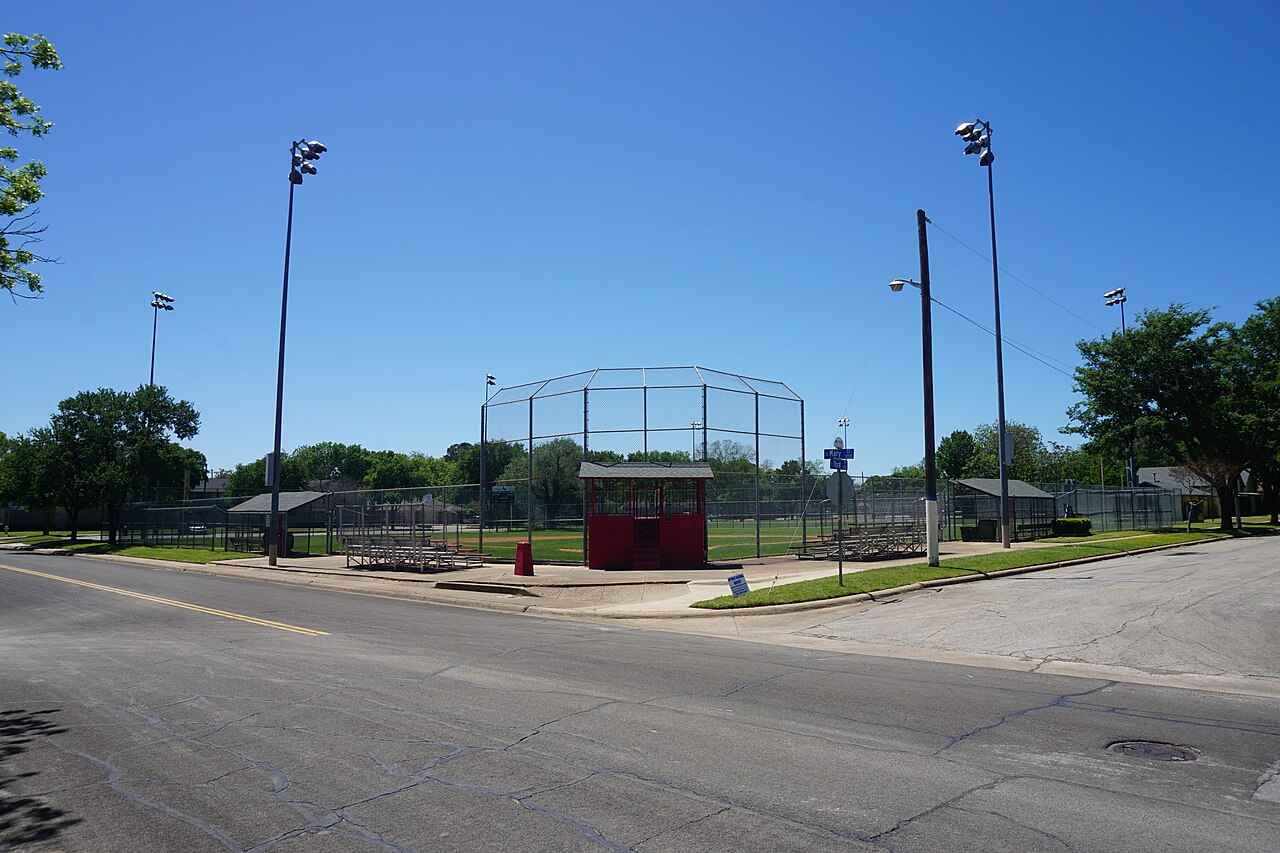 A neighborhood baseball diamond with a backstop and bleachers