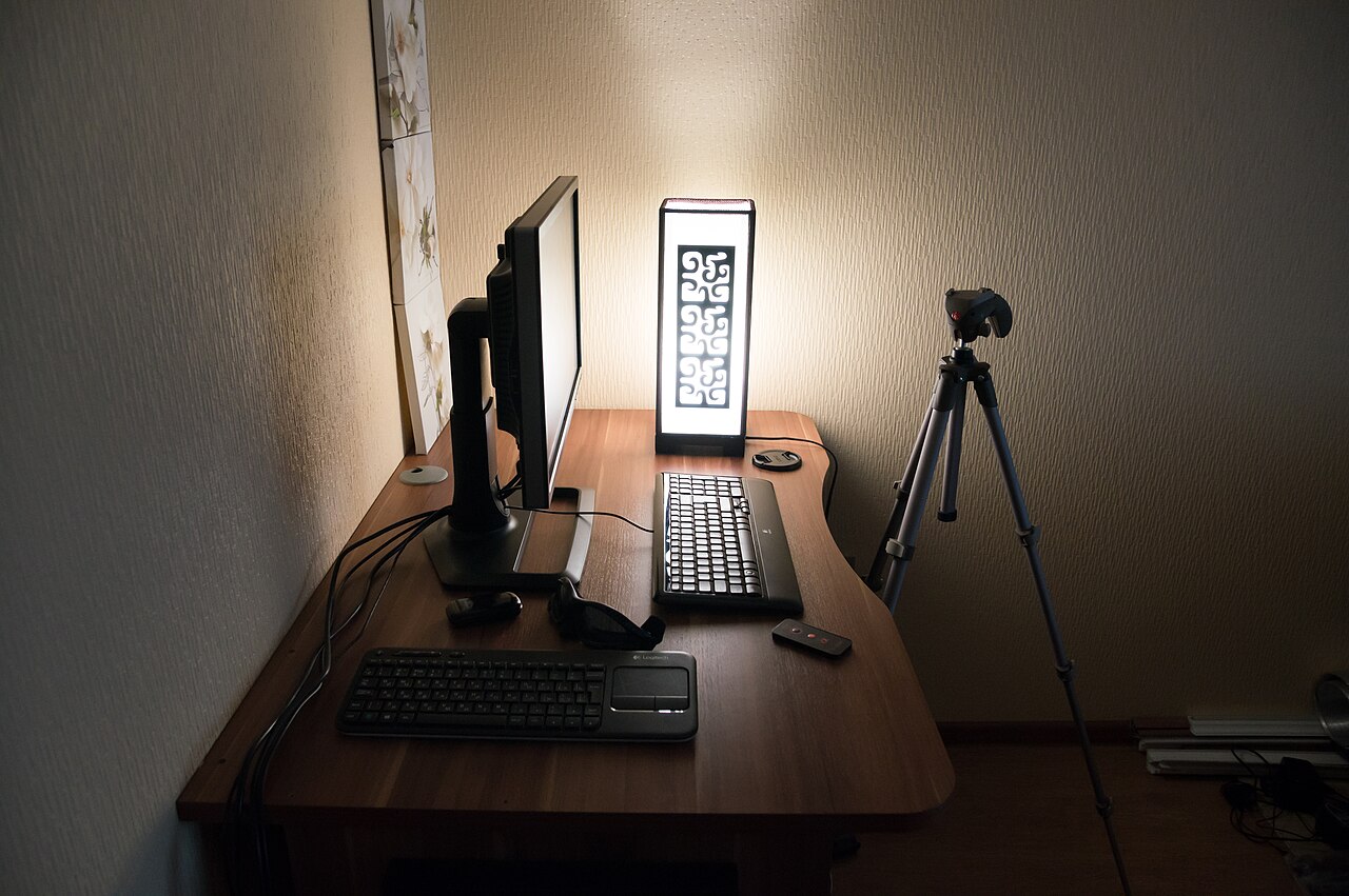 A home computer desk with a monitor, keyboard, and mouse