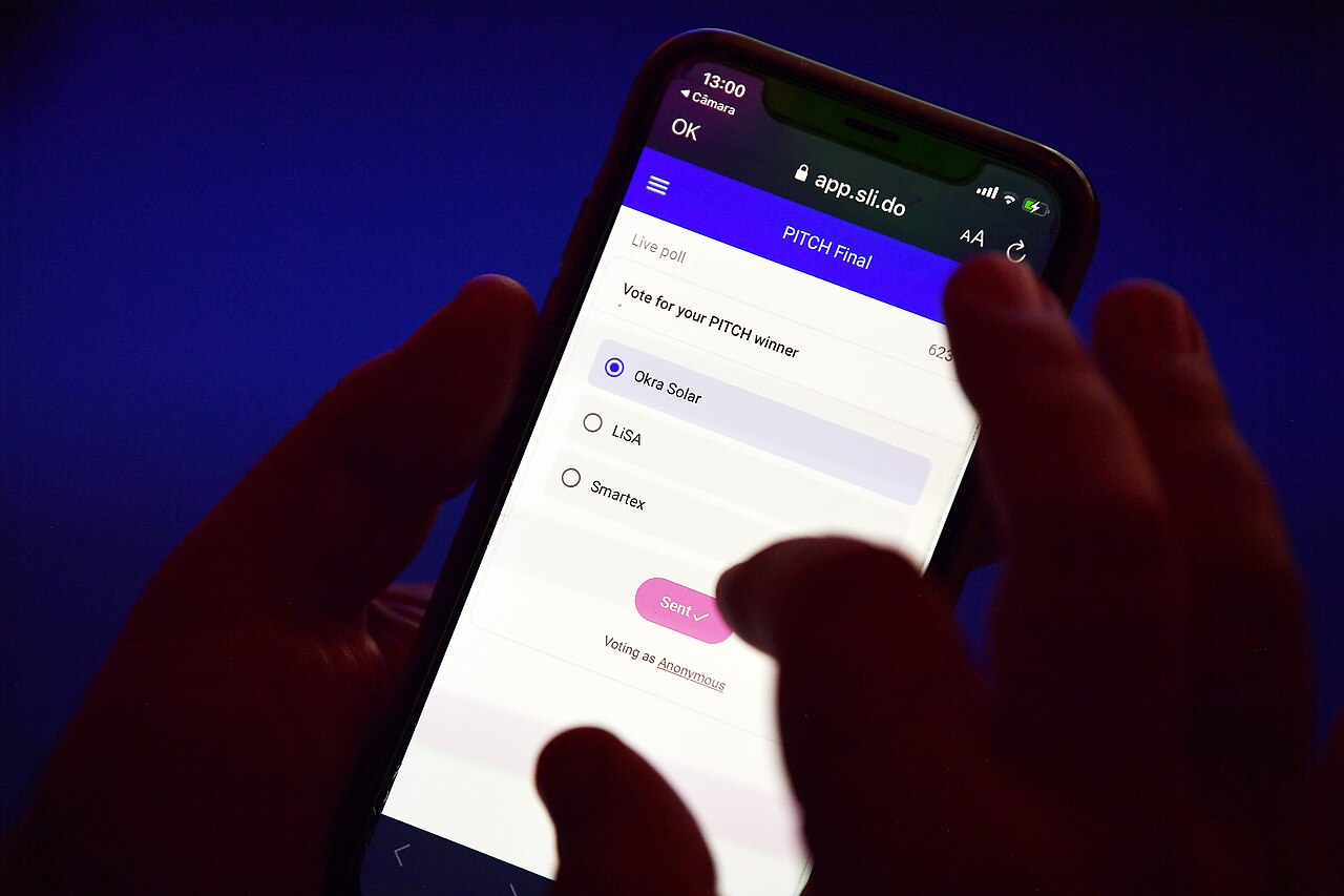 Two hands holding a smartphone and tapping the screen